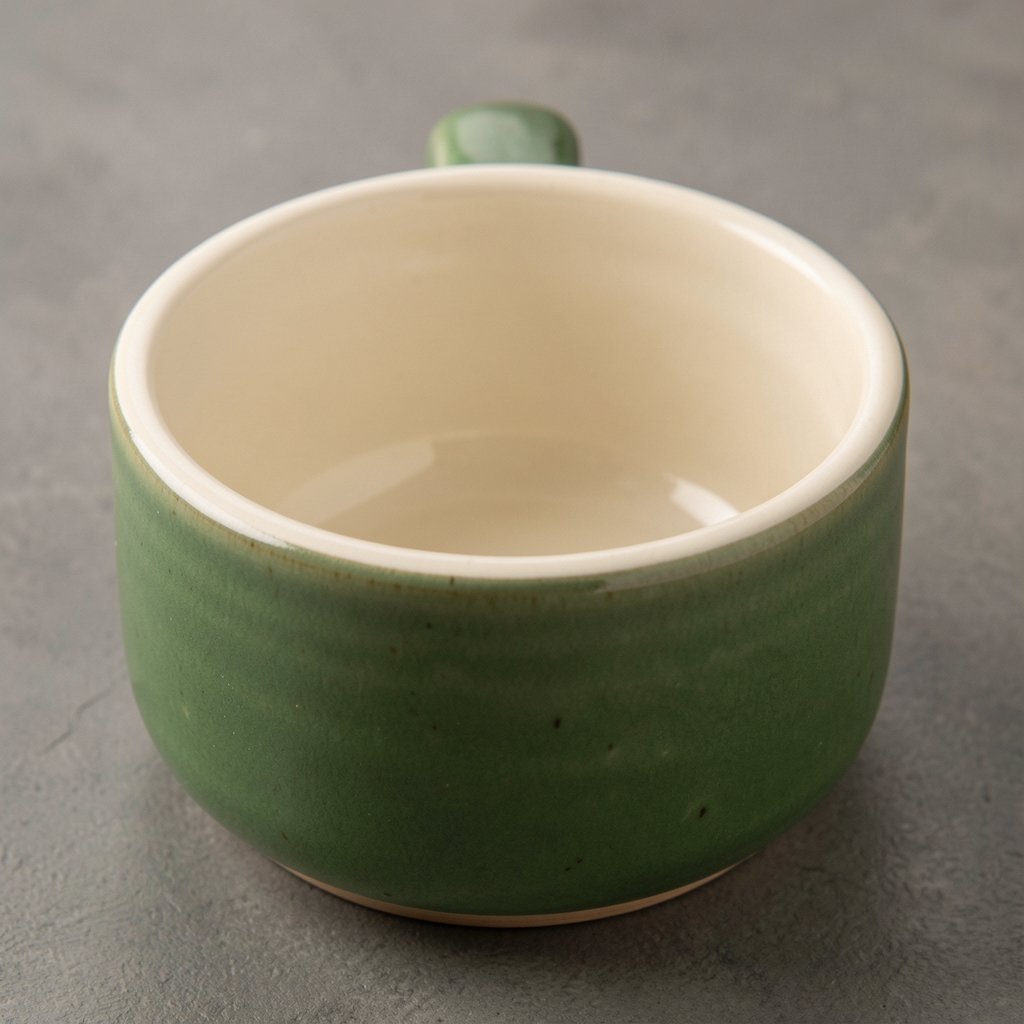 Zeytin yeşili stoneware kasenin iç yüzeyindeki açık krem dokuyu ve kenar kalınlığını gösteren yakın ürün çekimi